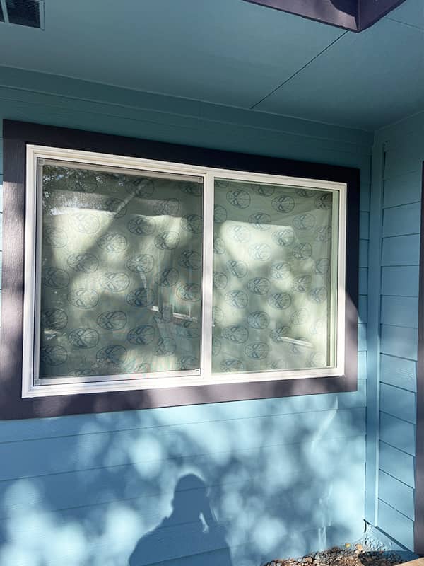 White sliding replacement window in blue siding in Austin, TX