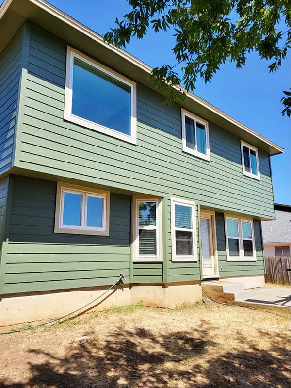 New windows on a green two-story home in Austin, TX