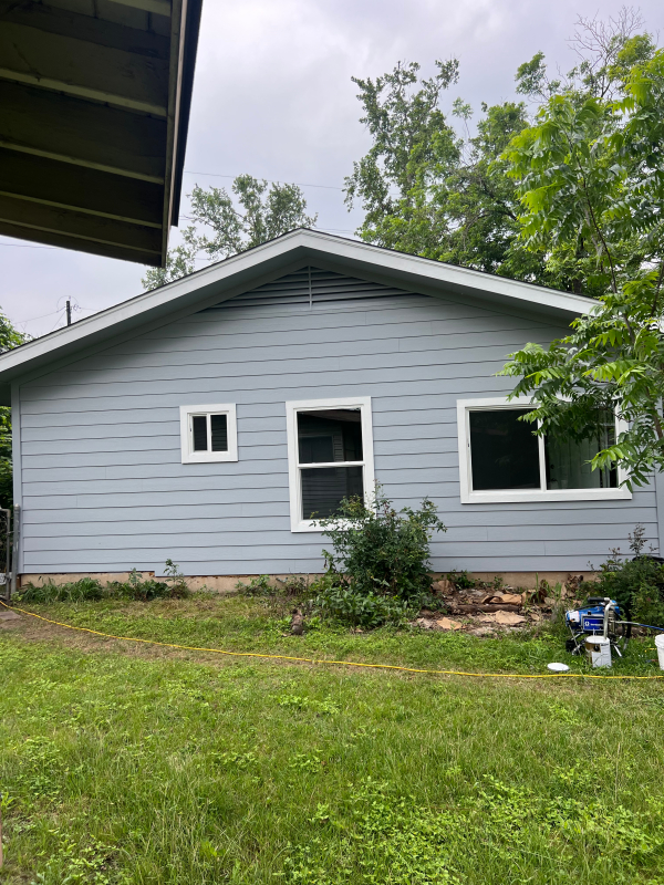 New windows on a single-story home with light blue siding in Austin, TX