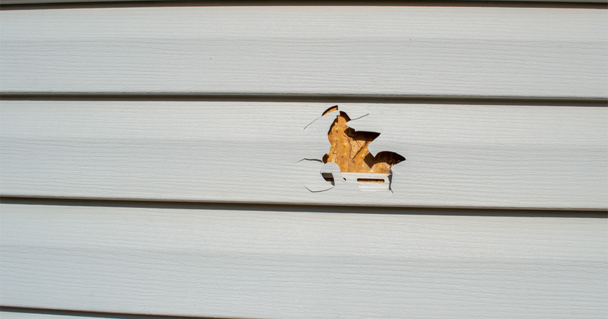 damaged siding repair showing cracked and warped exterior panels