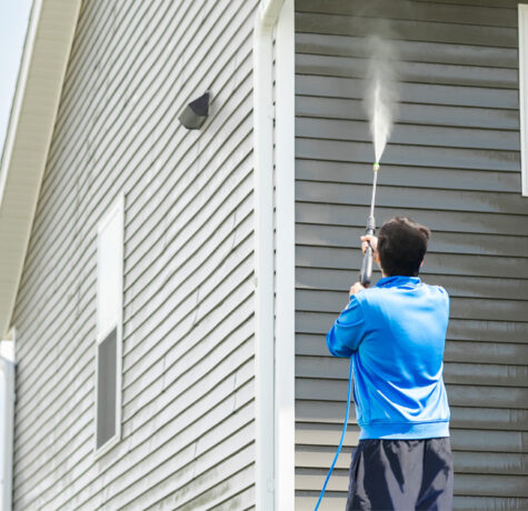 Homeowner showing how to maintain siding with exterior cleaning and inspection tips