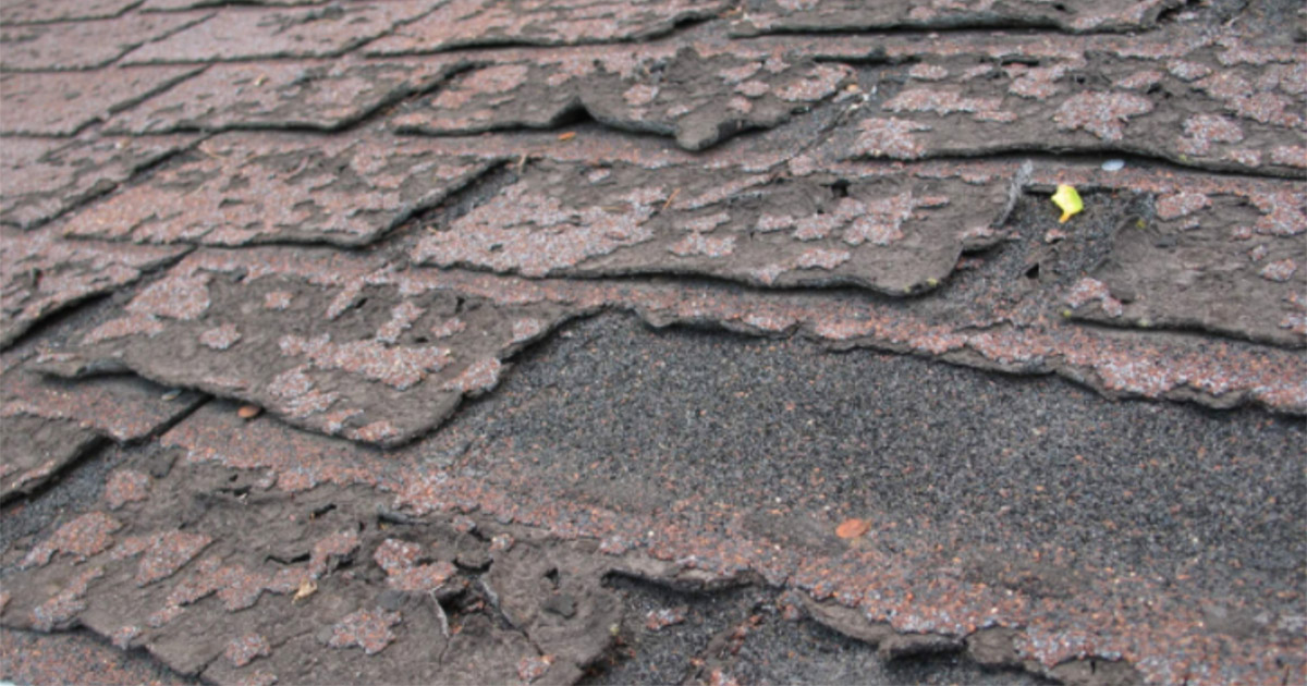 Asphalt shingle roofing with visible curling and cracked shingles caused by heat exposure and aging materials