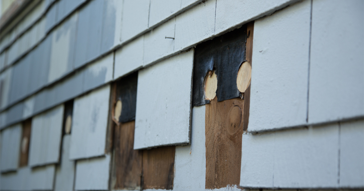 Shingle Siding Replacement showing cracked and weathered exterior shingles on a residential home