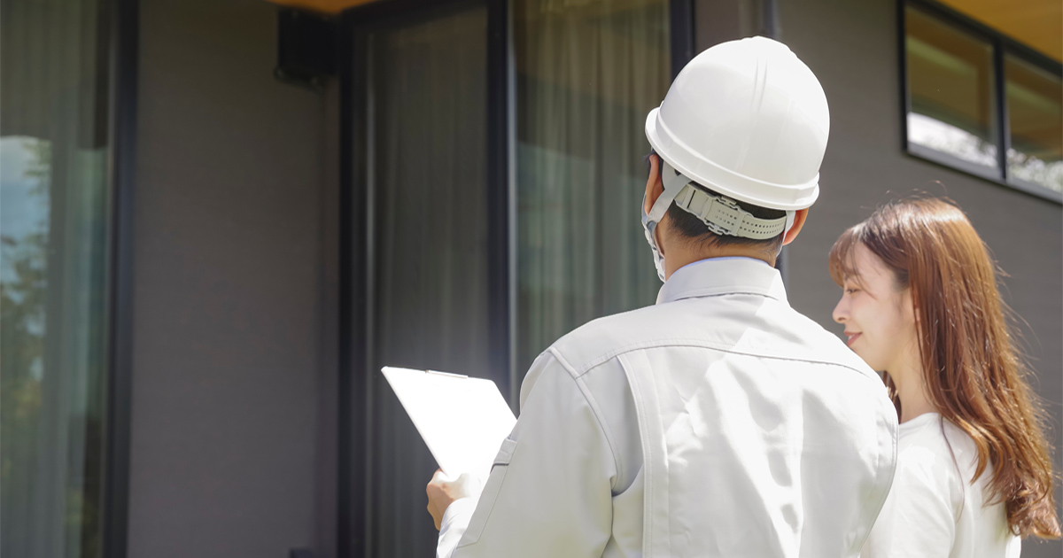 Homeowner reviewing a siding estimate with a contractor outside her Austin, TX home