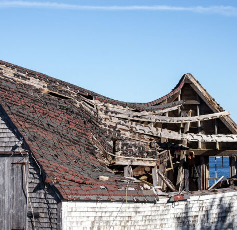 Old wooden house with a sagging, collapsing roof structure