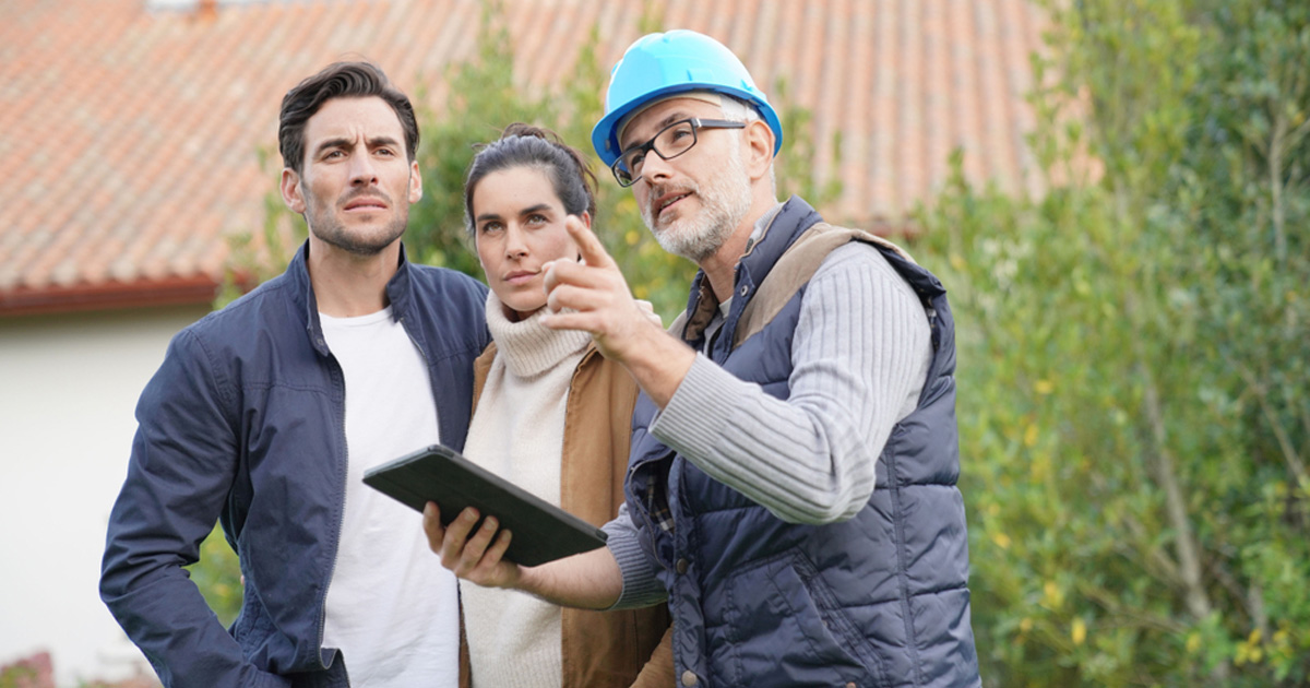 Roofing contractor reviewing a roof replacement plan with homeowners in McNeil, TX, near Austin