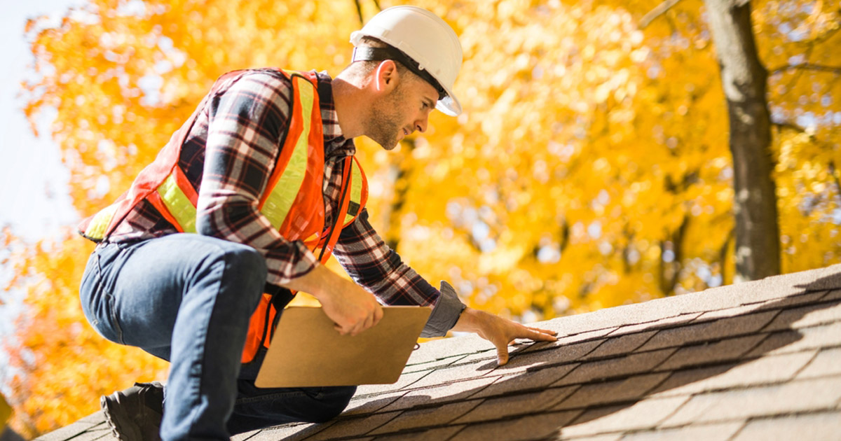 Roofer inspecting asphalt shingles on a home in Windemere, TX, near Austin