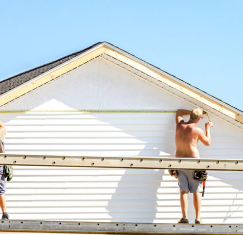 Installers on scaffolding putting up white lap siding on a home gable in Austin, TX